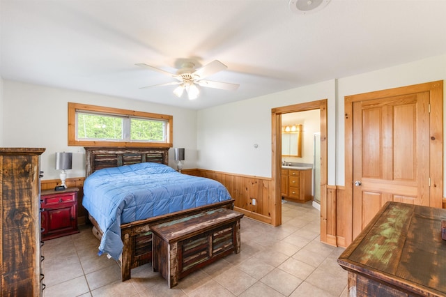 174 Sky View Rd, Stratford, NH 03590 - bedroom featuring a wainscoted wall, light tile patterned flooring, wood walls, ensuite bath, and ceiling fan