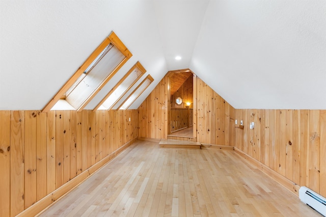 174 Sky View Rd, Stratford, NH 03590 - additional living space with a baseboard radiator, hardwood / wood-style floors, wooden walls, and vaulted ceiling
