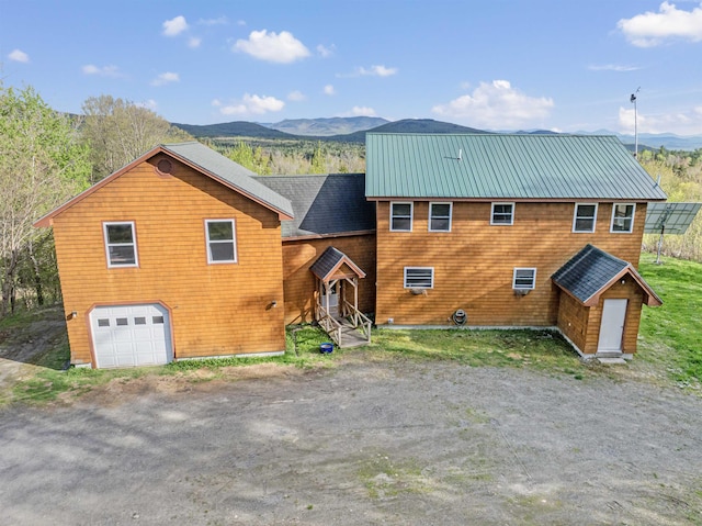 174 Sky View Rd, Stratford, NH 03590 - view of front facade with an attached garage, a mountain view, driveway, and a storage shed