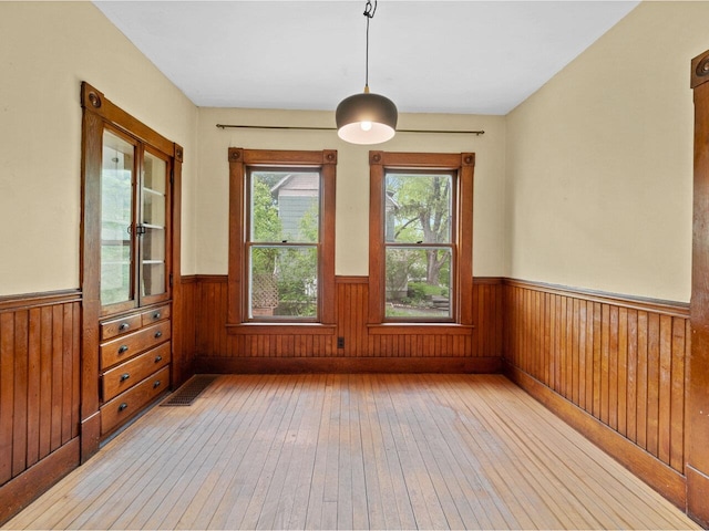 27 Ridge St, Montpelier, VT 05602 - unfurnished dining area with light wood-style floors, wainscoting, and wood walls