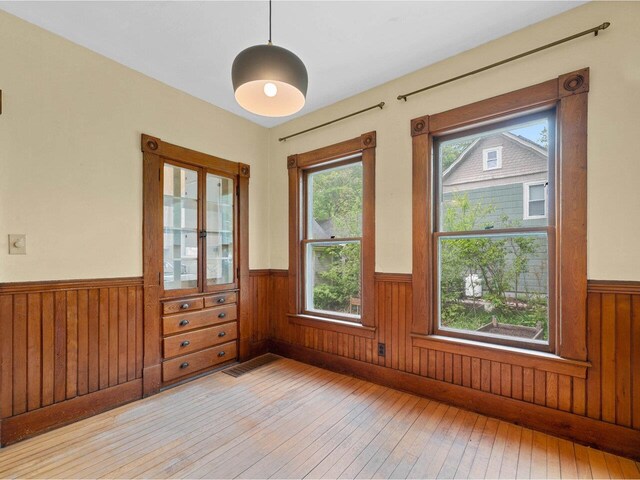 27 Ridge St, Montpelier, VT 05602 - spare room featuring wainscoting, light wood-type flooring, plenty of natural light, and wooden walls