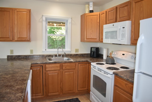 11 Creighton St, Newmarket, NH 03857 - kitchen featuring white appliances, a sink, dark countertops, and brown cabinetry