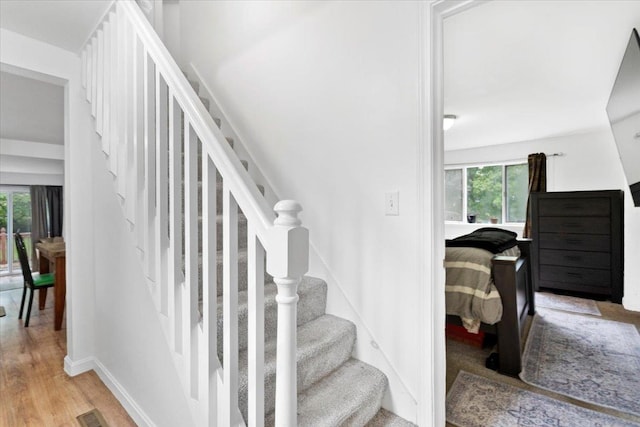 19 Overland St, Laconia, NH 03246 - staircase with healthy amount of natural light, wood finished floors, and baseboards