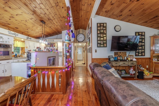 110 Nh Dr, Webster, NH 03303 - living room featuring vaulted ceiling, wainscoting, wood-type flooring, wooden ceiling, and wooden walls