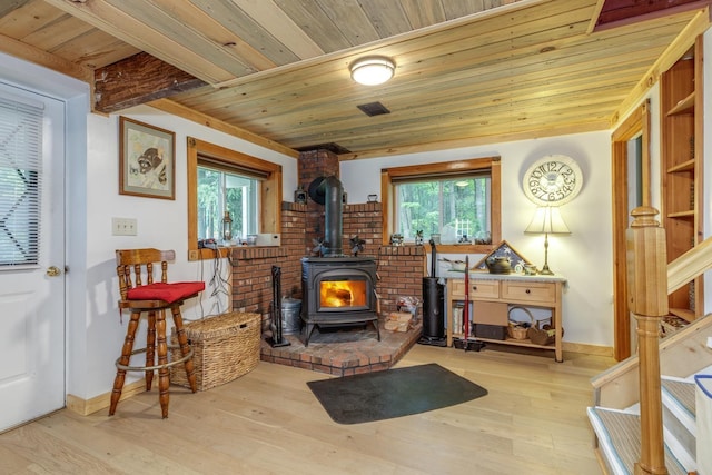 110 Nh Dr, Webster, NH 03303 - living area with wood ceiling, a wood stove, plenty of natural light, wood finished floors, and baseboards