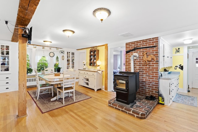 166 New Boston Rd, Goffstown, NH 03045 - dining space featuring light wood-style flooring, a wood stove, and radiator