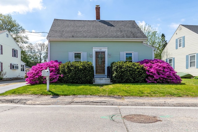 129 Indigo Hill Rd, Somersworth, NH 03878 - view of front of house featuring entry steps, a chimney, a front yard, and a shingled roof