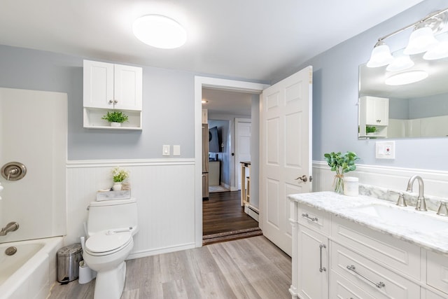 129 Indigo Hill Rd, Somersworth, NH 03878 - full bath featuring wood finished floors, vanity, wainscoting, toilet, and washtub / shower combination
