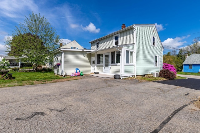 129 Indigo Hill Rd, Somersworth, NH 03878 - view of front of home with a chimney, cooling unit, and a front lawn