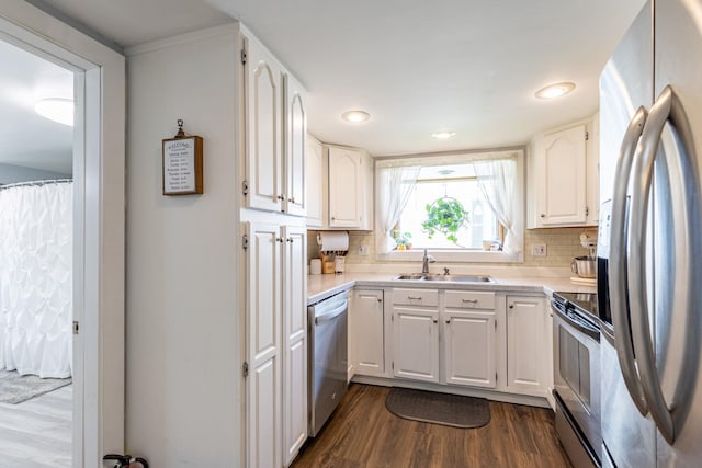 129 Indigo Hill Rd, Somersworth, NH 03878 - kitchen with appliances with stainless steel finishes, a sink, dark wood-style flooring, backsplash, and white cabinetry