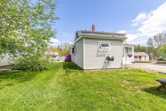 129 Indigo Hill Rd, Somersworth, NH 03878 - back of house featuring a lawn and a chimney