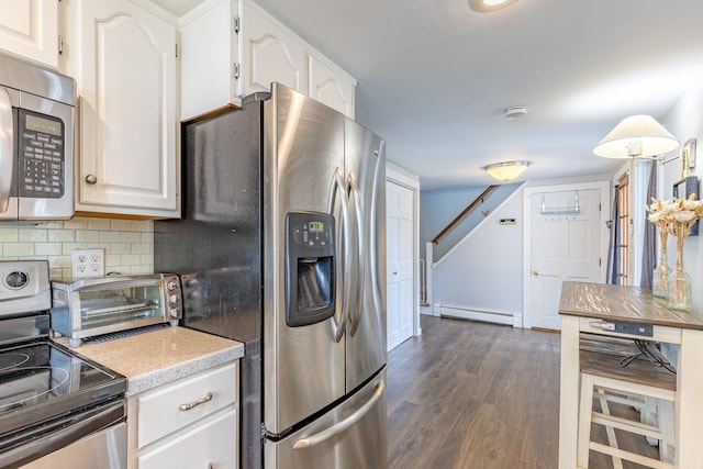 129 Indigo Hill Rd, Somersworth, NH 03878 - kitchen featuring appliances with stainless steel finishes, a baseboard radiator, dark wood finished floors, backsplash, and white cabinetry