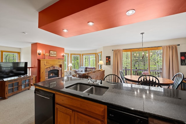 143 Bridge Rd Unit Vc331, Jay, VT 05859 - kitchen featuring dishwasher, a sink, open floor plan, a brick fireplace, and light carpet