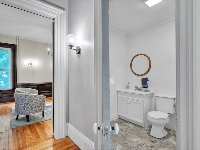 65 Congress St, Saint Albans City, VT 05478 - bathroom featuring crown molding, vanity, toilet, baseboards, and wood finished floors