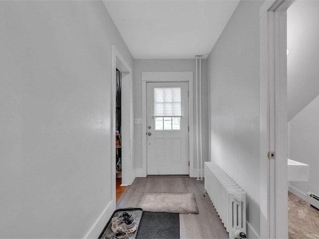 65 Congress St, Saint Albans City, VT 05478 - doorway to outside with radiator heating unit, light wood-type flooring, and baseboards