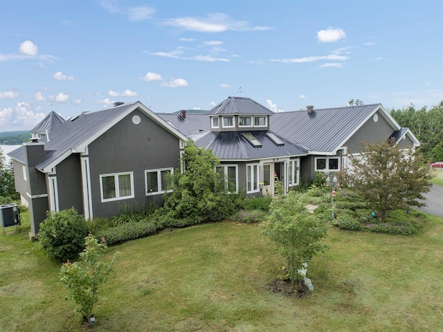 128 Fuller Dr, Canaan, VT 05903 - rear view of house with stucco siding, metal roof, and a yard
