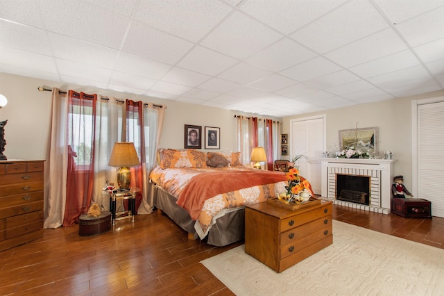128 Fuller Dr, Canaan, VT 05903 - bedroom with a paneled ceiling, dark wood-type flooring, and a brick fireplace