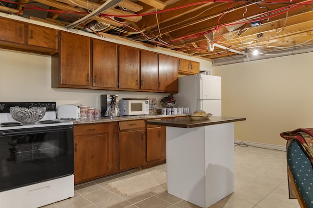 128 Fuller Dr, Canaan, VT 05903 - kitchen with white appliances, brown cabinetry, a kitchen island, dark countertops, and baseboards