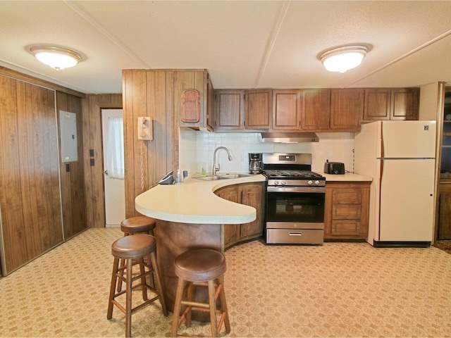 244 Tranquility Ln, Saint Albans Town, VT 05478 - kitchen featuring freestanding refrigerator, gas stove, under cabinet range hood, a sink, and light countertops