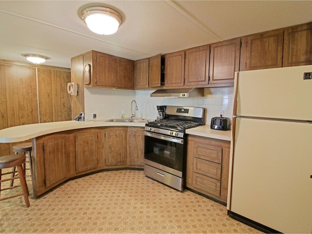 244 Tranquility Ln, Saint Albans Town, VT 05478 - kitchen featuring freestanding refrigerator, gas stove, a sink, and brown cabinetry