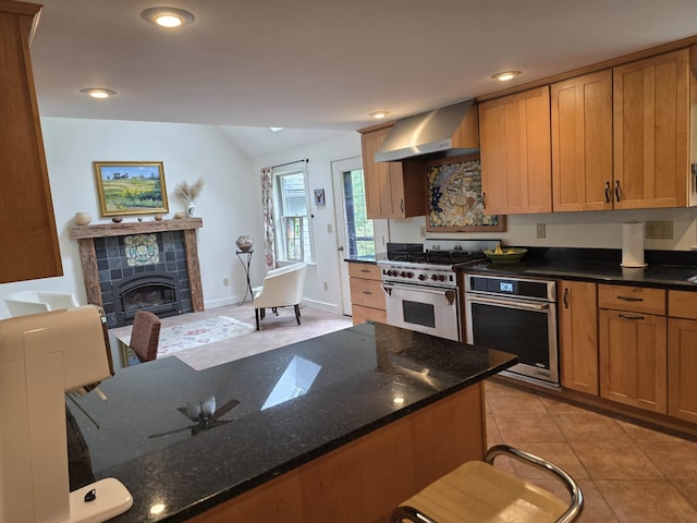 1073 Upper Dummerston Rd, Brattleboro, VT 05301 - kitchen featuring wall chimney exhaust hood, stainless steel appliances, vaulted ceiling, recessed lighting, and dark stone countertops