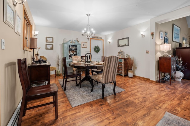 8 Mill Pond Rd, Grantham, NH 03753 - dining space featuring wood finished floors, a chandelier, baseboards, and a baseboard radiator