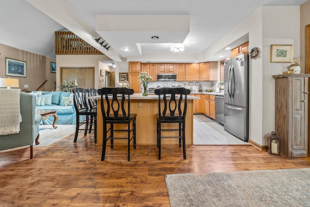 8 Mill Pond Rd, Grantham, NH 03753 - kitchen featuring stainless steel appliances, a breakfast bar area, light wood-style floors, light countertops, and open floor plan