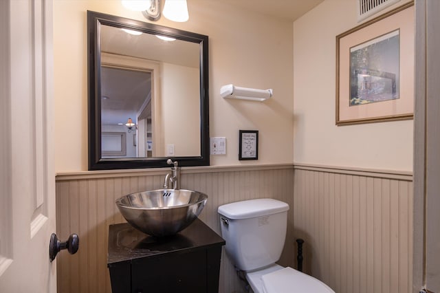 5 N Main St, Wilmington, VT 05363 - half bath featuring a wainscoted wall, vanity, and toilet