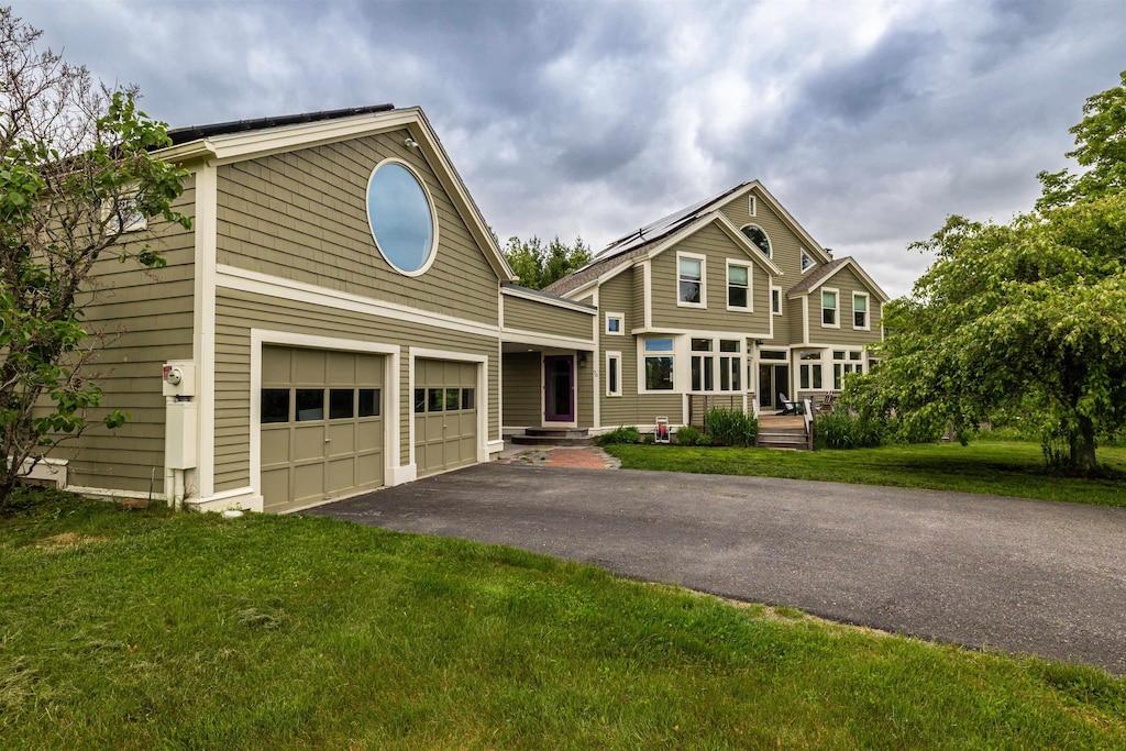70 Fisk Rd, Concord, NH 03301 - view of front of house featuring asphalt driveway, a front lawn, and a garage
