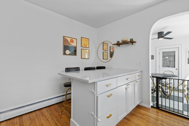 7 Lamson Ln, Hampton, NH 03842 - kitchen featuring a baseboard radiator, light wood-style flooring, light countertops, and white cabinets