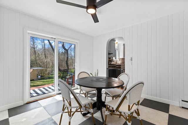 7 Lamson Ln, Hampton, NH 03842 - dining room with arched walkways, a ceiling fan, baseboards, and a decorative wall