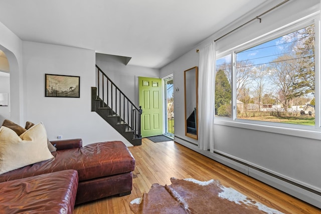 7 Lamson Ln, Hampton, NH 03842 - living area featuring baseboard heating, wood finished floors, arched walkways, and stairs