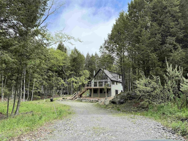 62 Highland Vws N, Ludlow, VT 05149 - view of front of home featuring gravel driveway, stairs, a wooden deck, and a wooded view