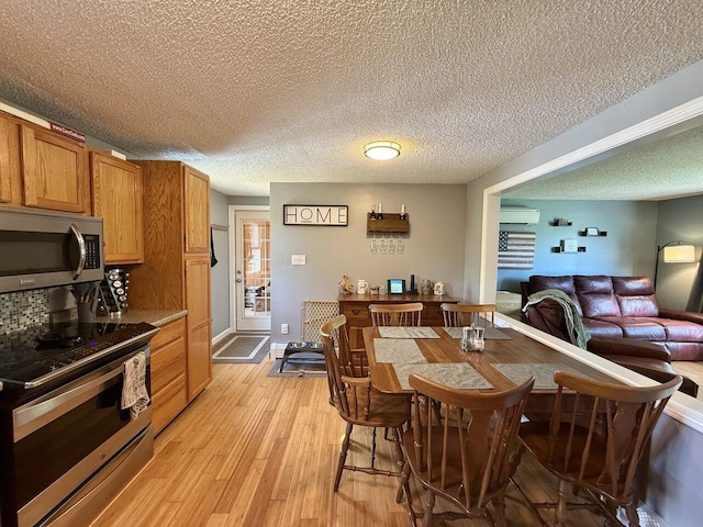 50 New Haven Rd, Vergennes, VT 05491 - dining space with a textured ceiling, light wood-style floors, and a wall mounted air conditioner