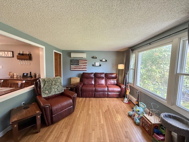 50 New Haven Rd, Vergennes, VT 05491 - living area with an AC wall unit, a textured ceiling, hardwood / wood-style floors, and healthy amount of natural light