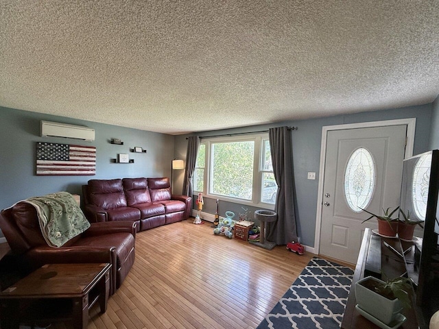 50 New Haven Rd, Vergennes, VT 05491 - living area with a wall mounted air conditioner, a textured ceiling, wood-type flooring, and baseboards