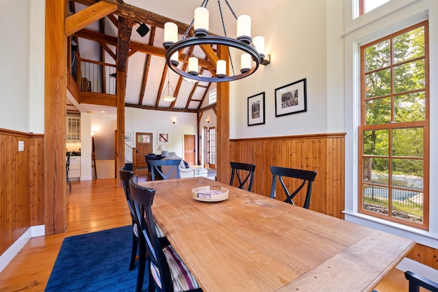 10 Wiswall Hill Rd, Newfane, VT 05345 - dining space featuring a chandelier, high vaulted ceiling, wooden walls, wainscoting, and wood finished floors