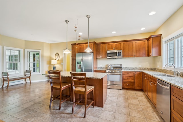 222 Park View Rd, Springfield, VT 05156 - kitchen with appliances with stainless steel finishes, a sink, brown cabinets, a center island, and light stone counters