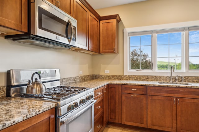 222 Park View Rd, Springfield, VT 05156 - kitchen featuring stainless steel appliances, a sink, brown cabinetry, and light stone counters