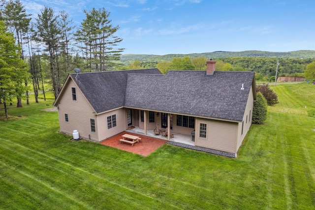 222 Park View Rd, Springfield, VT 05156 - view of front facade with a chimney, a patio area, a front lawn, and a shingled roof