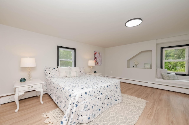 42 College Rd, Stratham, NH 03885 - bedroom featuring multiple windows, light wood-type flooring, and a baseboard heating unit