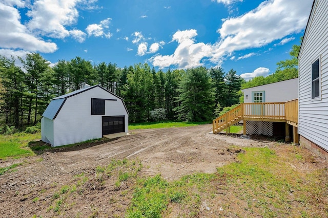 42 College Rd, Stratham, NH 03885 - view of yard featuring a garage, a wooden deck, an outdoor structure, and dirt driveway