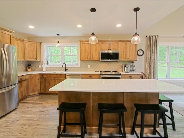 1585 Amidon Rd Unit 1, 2, 3, Montgomery, VT 05471 - kitchen with stainless steel appliances, a sink, backsplash, light wood-type flooring, and a breakfast bar area