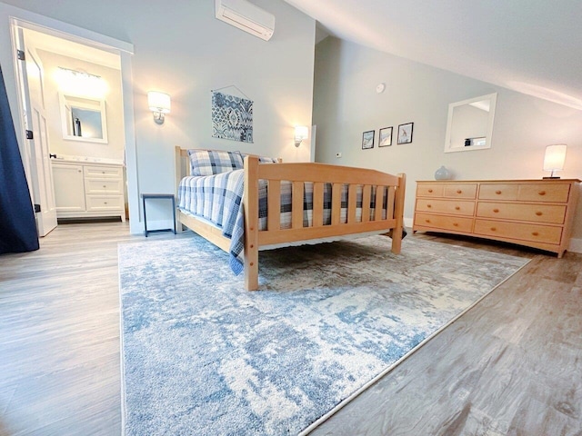1585 Amidon Rd Unit 1, 2, 3, Montgomery, VT 05471 - bedroom featuring vaulted ceiling, wood finished floors, an AC wall unit, baseboards, and connected bathroom