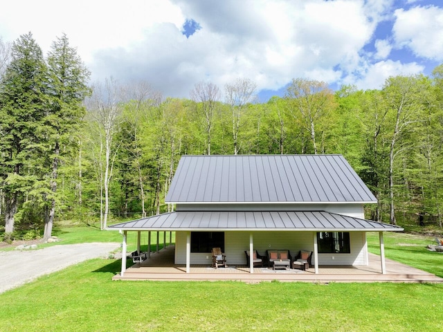 1585 Amidon Rd Unit 1, 2, 3, Montgomery, VT 05471 - back of house with outdoor lounge area, a standing seam roof, a forest view, and a lawn