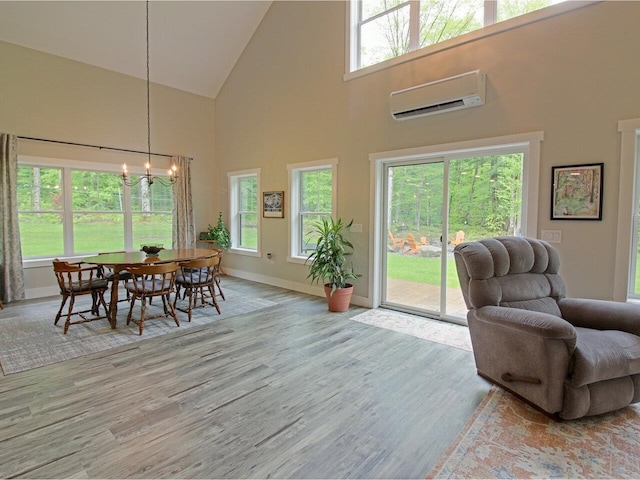 1585 Amidon Rd Unit 1, 2, 3, Montgomery, VT 05471 - dining space with a chandelier, a wall mounted air conditioner, high vaulted ceiling, wood finished floors, and baseboards
