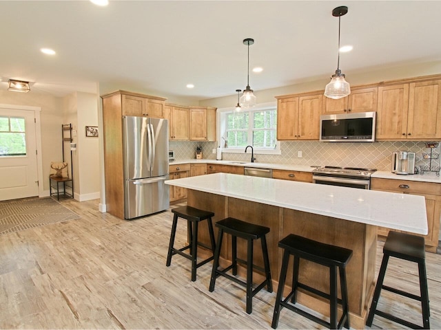 1585 Amidon Rd Unit 1, 2, 3, Montgomery, VT 05471 - kitchen featuring appliances with stainless steel finishes, light countertops, decorative backsplash, a breakfast bar, and light wood-type flooring