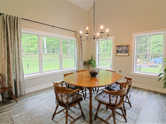 1585 Amidon Rd Unit 1, 2, 3, Montgomery, VT 05471 - dining area featuring healthy amount of natural light, a chandelier, baseboards, wood finished floors, and high vaulted ceiling