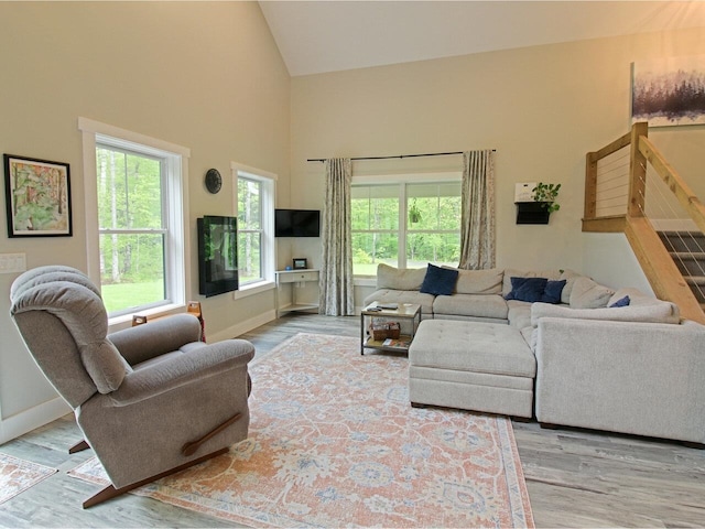 1585 Amidon Rd Unit 1, 2, 3, Montgomery, VT 05471 - living area with high vaulted ceiling, plenty of natural light, wood finished floors, baseboards, and stairway