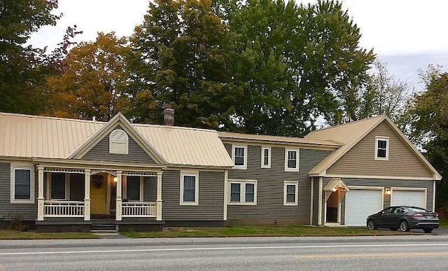 22 Chestnut St, Claremont, NH 03743 - view of front facade with covered porch, a garage, a chimney, and metal roof